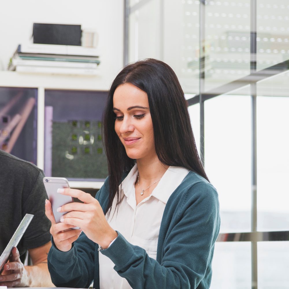 Professionnel consultant son téléphone pour suivre une relance de devis auprès d’un client potentiel.